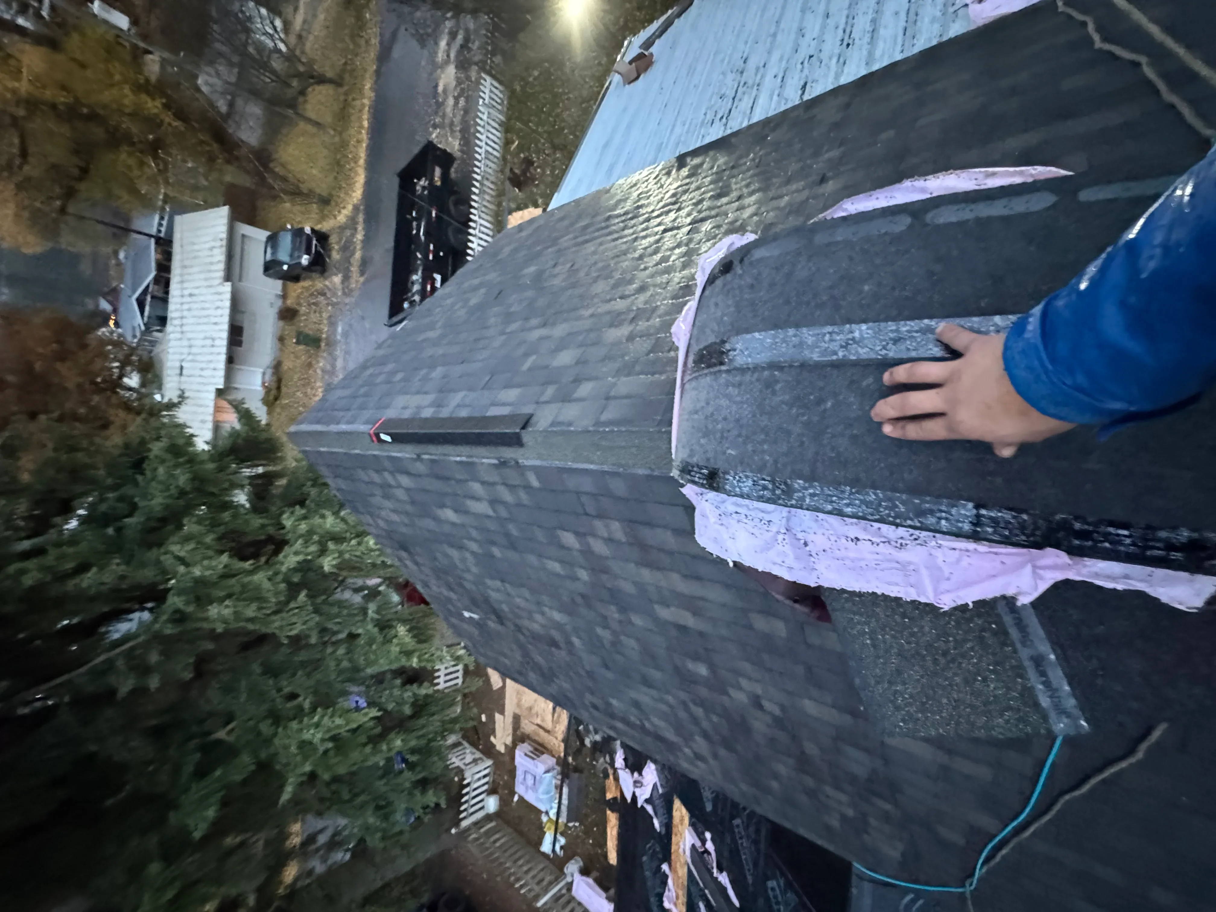 Asphalt shingle roof installation with underlayment and flashing detail work in progress