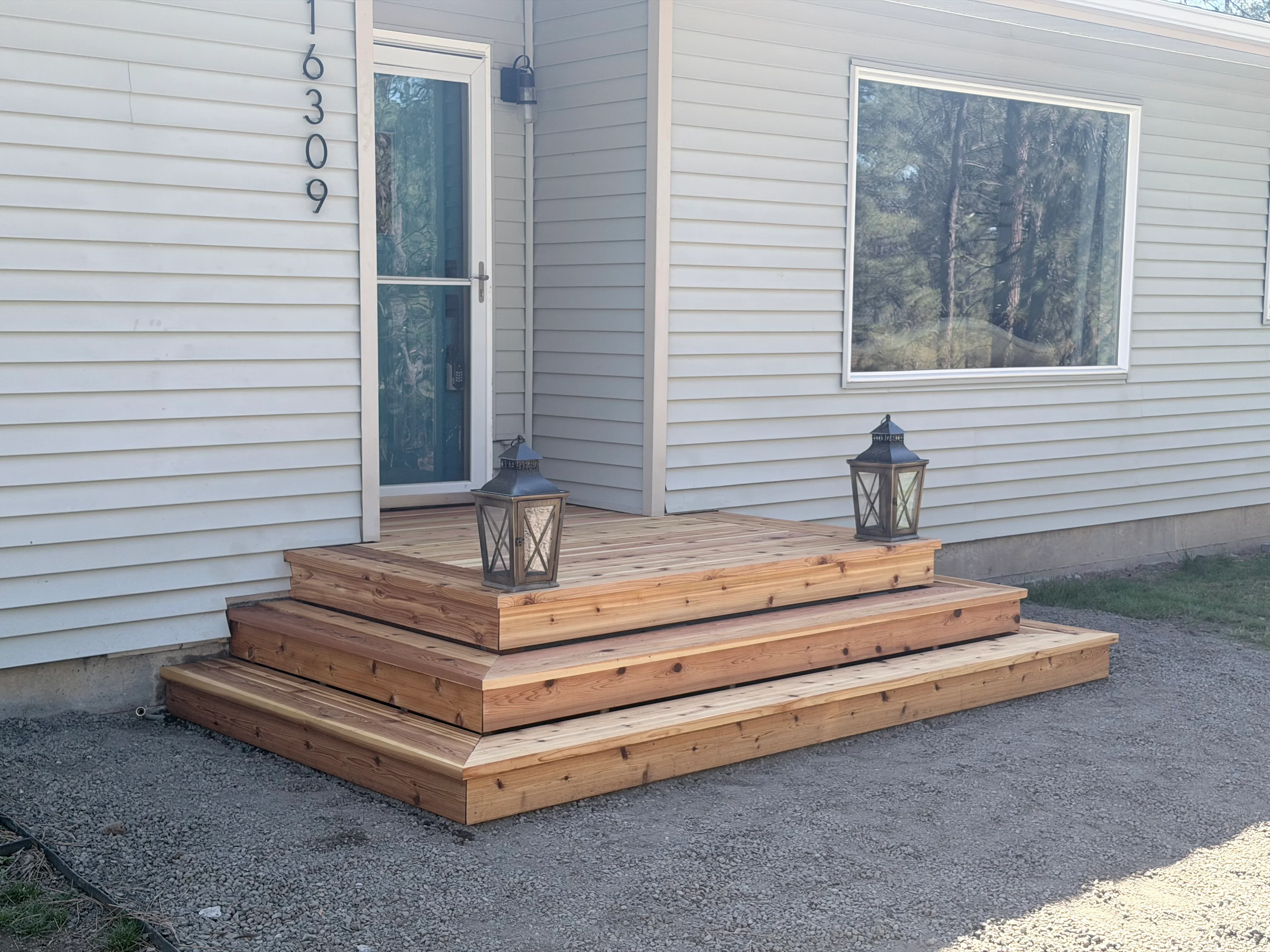 Three-tiered wooden deck platform with pressure-treated lumber and visible fasteners