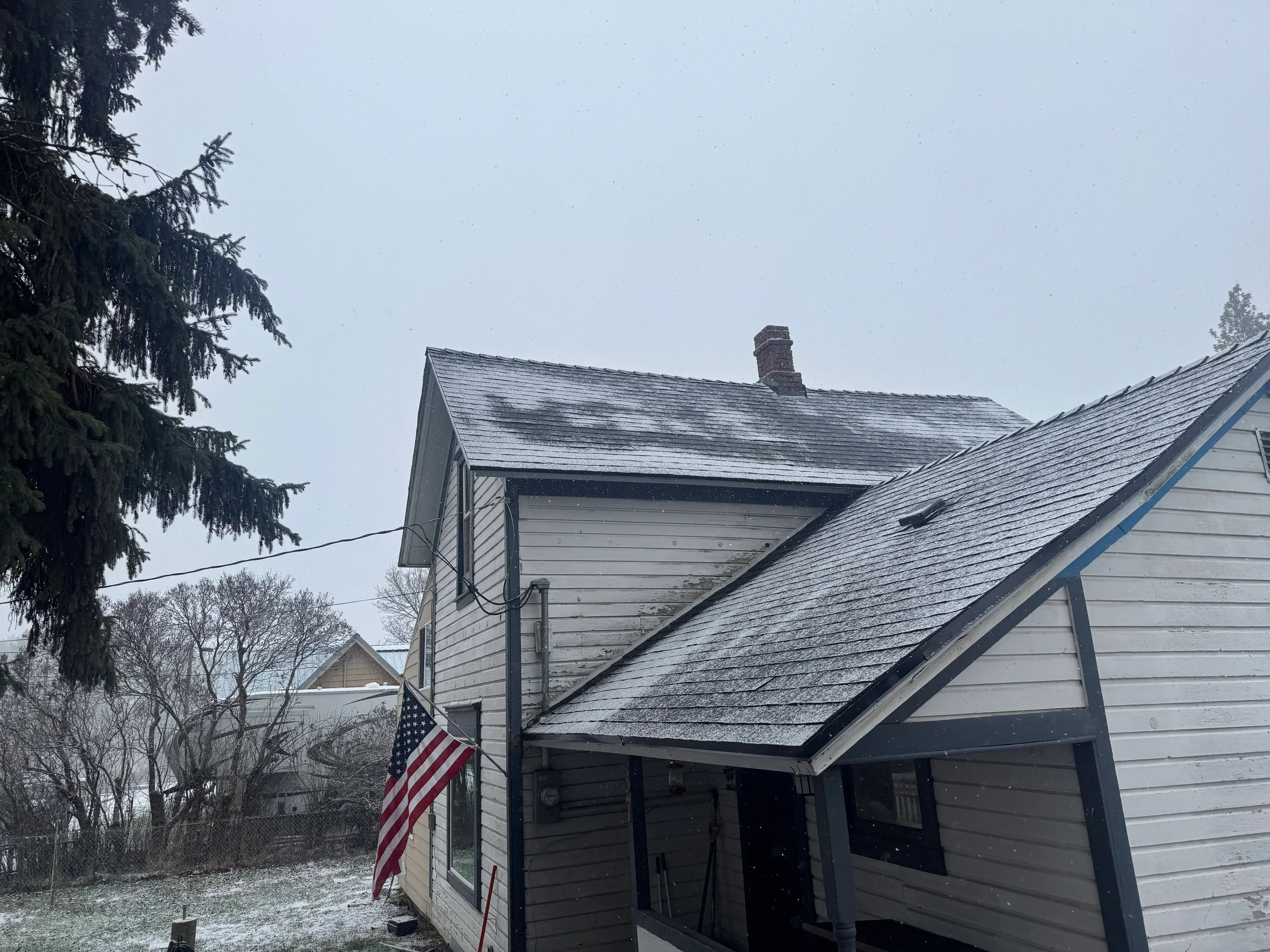 Residential home with new charcoal gray roof shingles and horizontal siding installation
