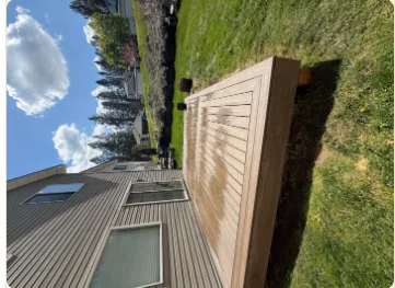 Gray composite deck with grooved boards and wood siding on residential home